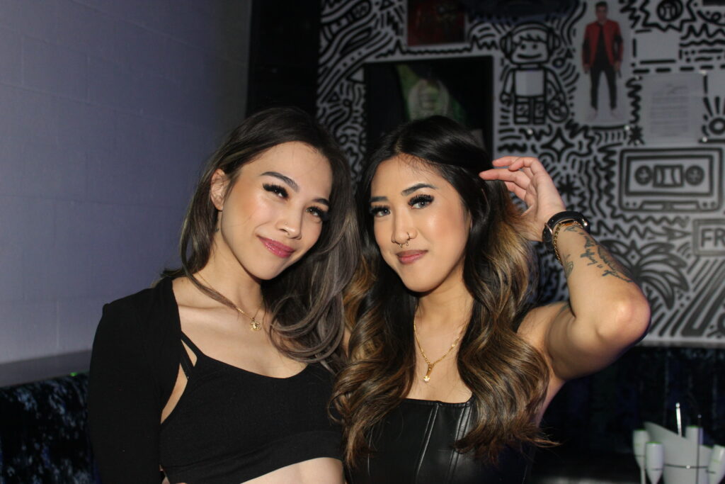 Friends posing together in front of artwork inside Audio Bar