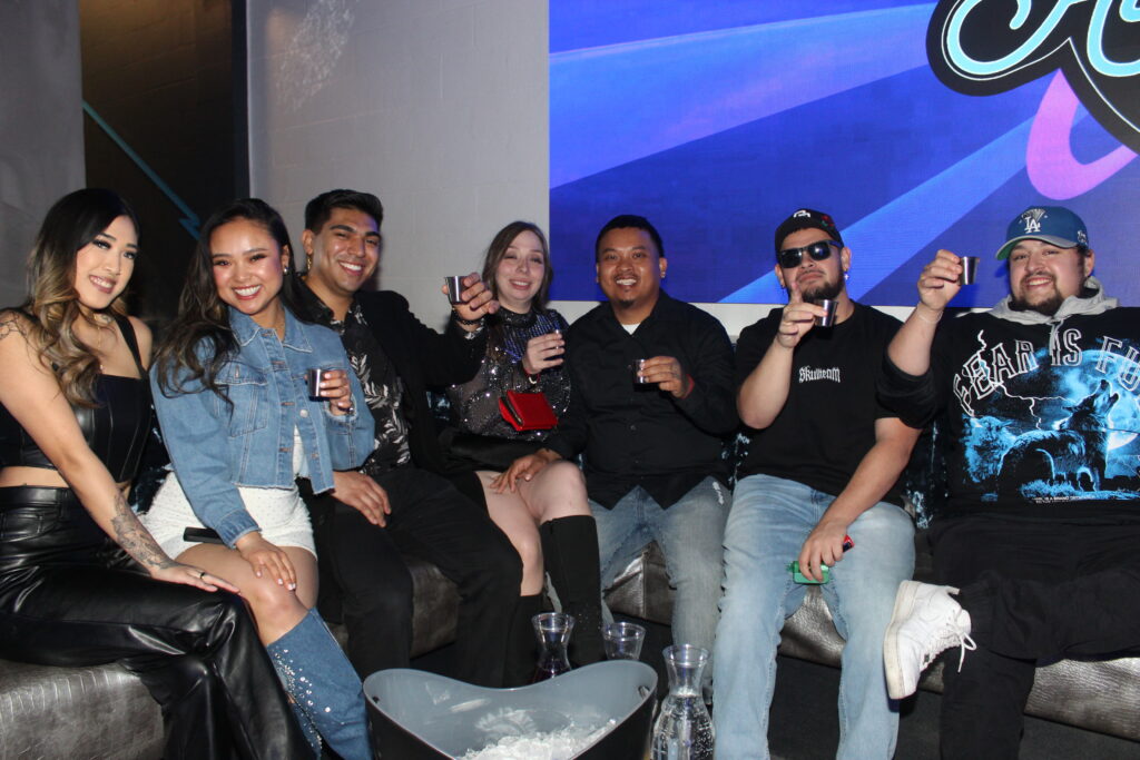 Friends seated together on a booth inside Audio Bar