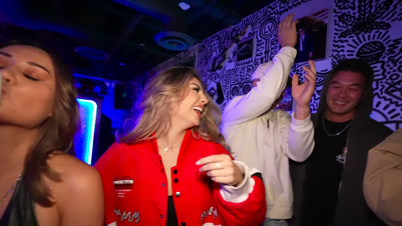 Real guests dancing together inside Audio Bar beneath its black-and-white mural