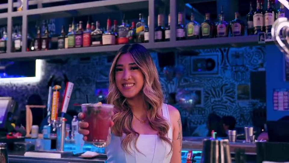 A bartender presenting a cocktail at Audio Bar